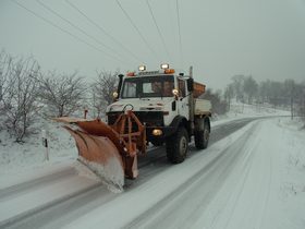 Unimog mit Schneepflug und Streuer im Winterdienst